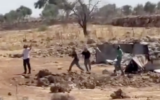 Settlers hurl stones, reportedly during clashes with Palestinians in the West Bank town of Sinjil on July 11, 2025. (Screen capture: Al-Jarmaq News)